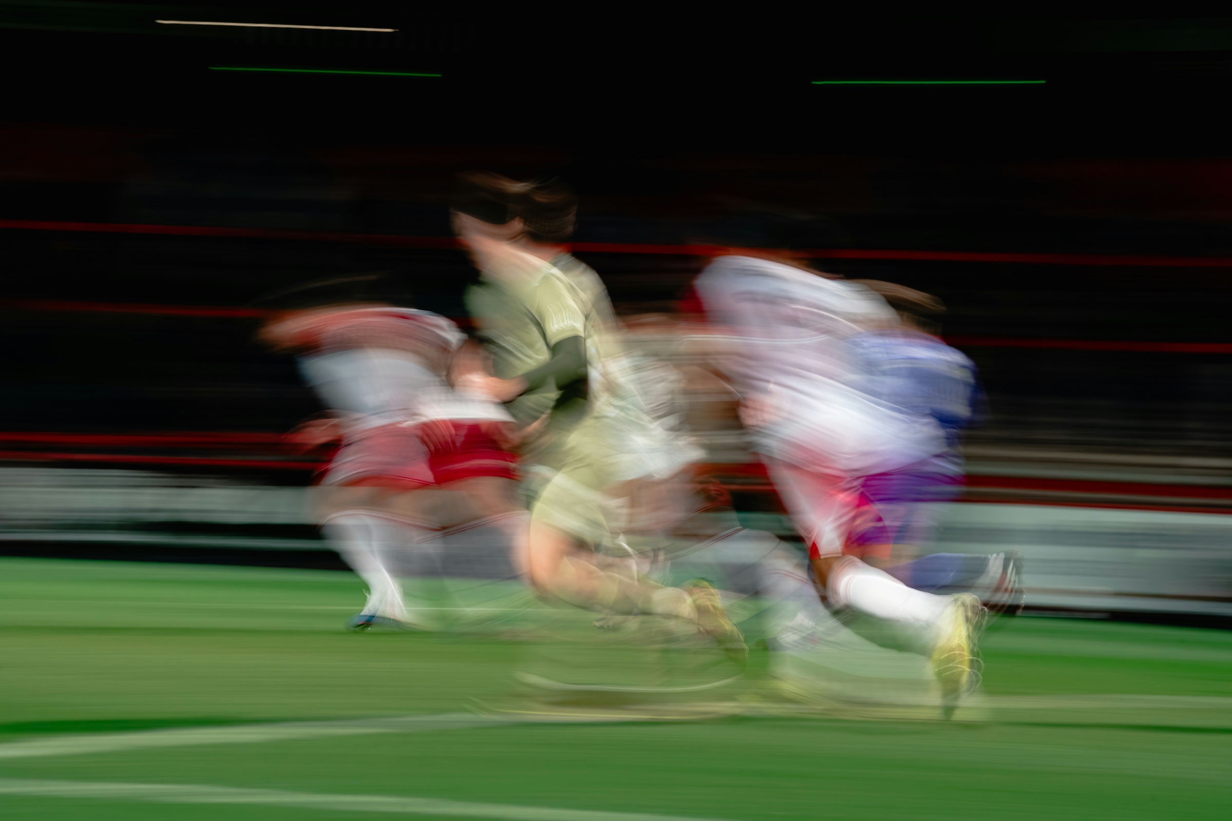 Football players sprinting across the field at speed