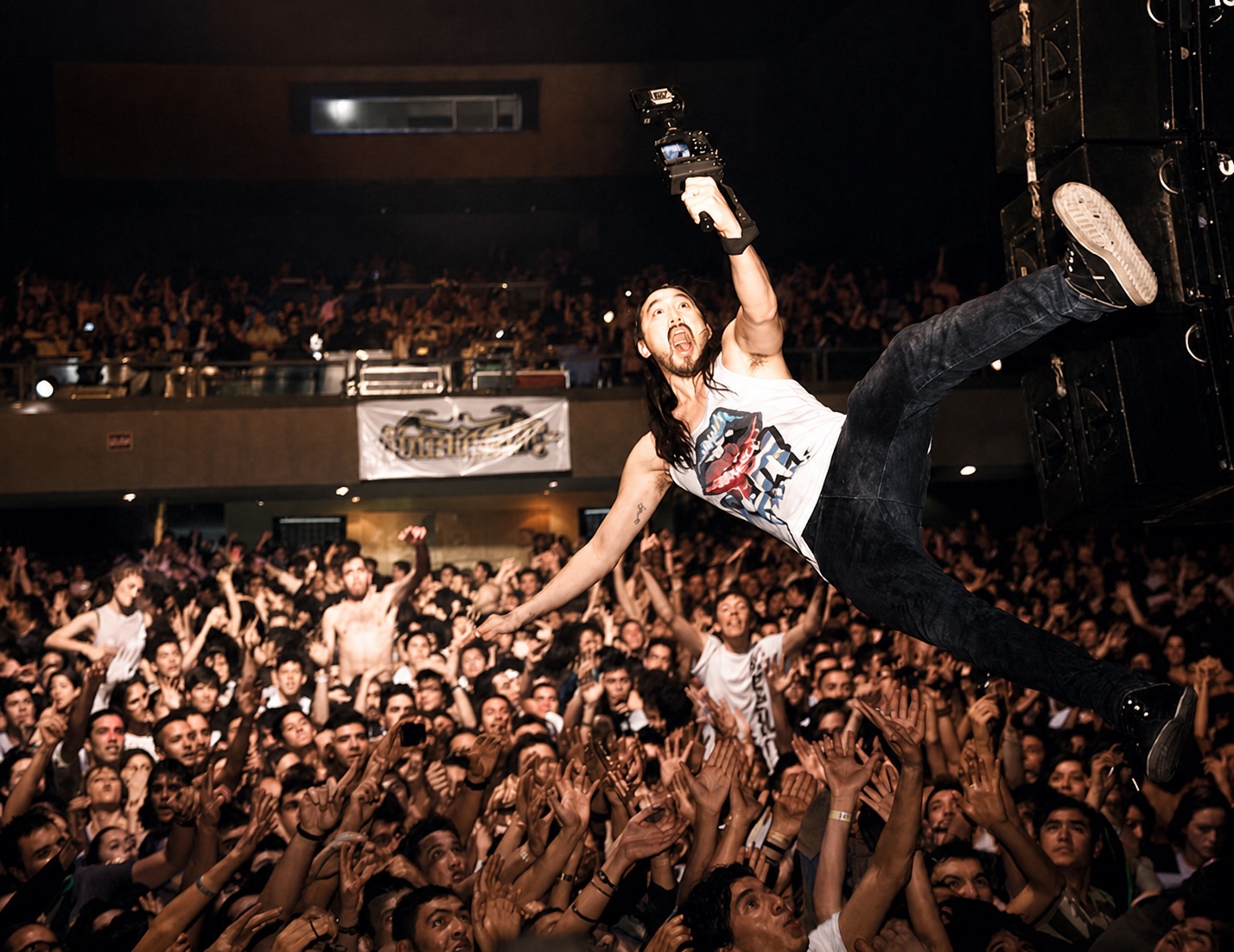 Steve Aoki performing over a live crowd